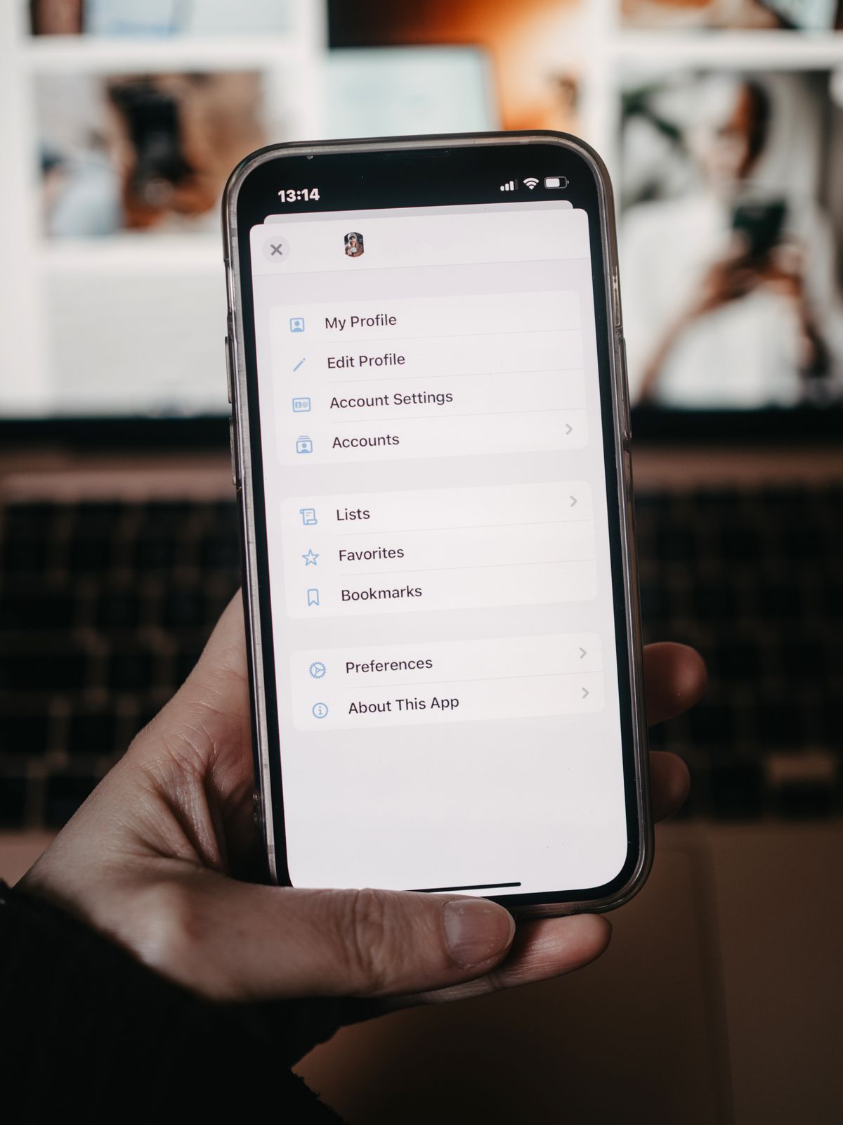 A hand holds a smartphone showing a settings menu with Account Settings and Accounts options, the kind of linked accounts a factory reset does not sign out of