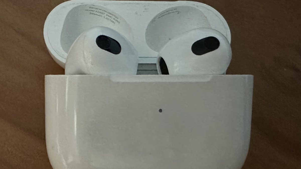 AirPods sitting in an open charging case, ready to be re-seated to force the earbuds to re-sync with the phone