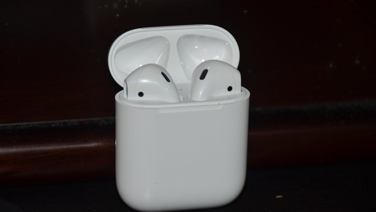 Two AirPods resting in an open white charging case, each earbud a separate speaker with its own battery and radio