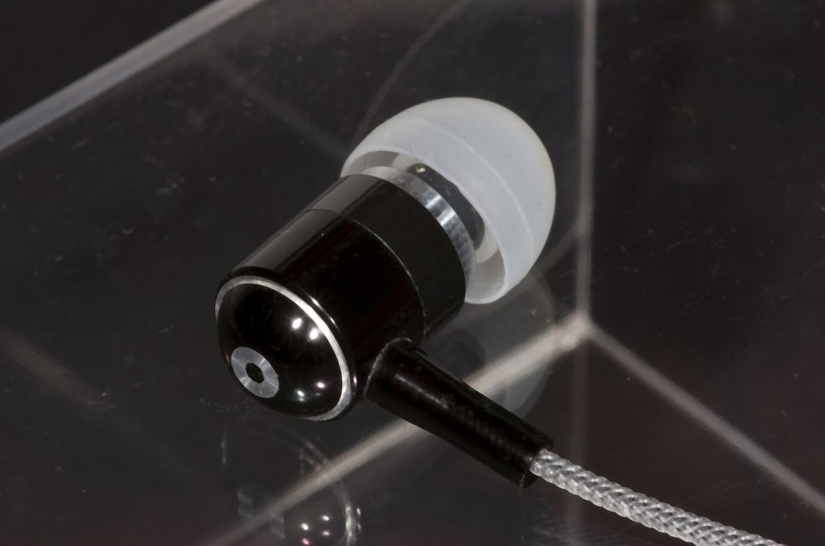 Macro photograph of an in-ear earphone fitted with a large silicone ear tip
