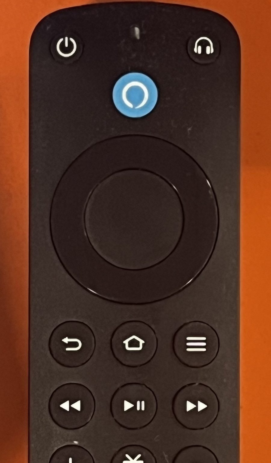 The top half of an Alexa Voice Remote Pro showing the tiny LED pinhole above the blue Alexa button, plus the Back, Home, Menu and playback buttons used to enter troubleshooting mode