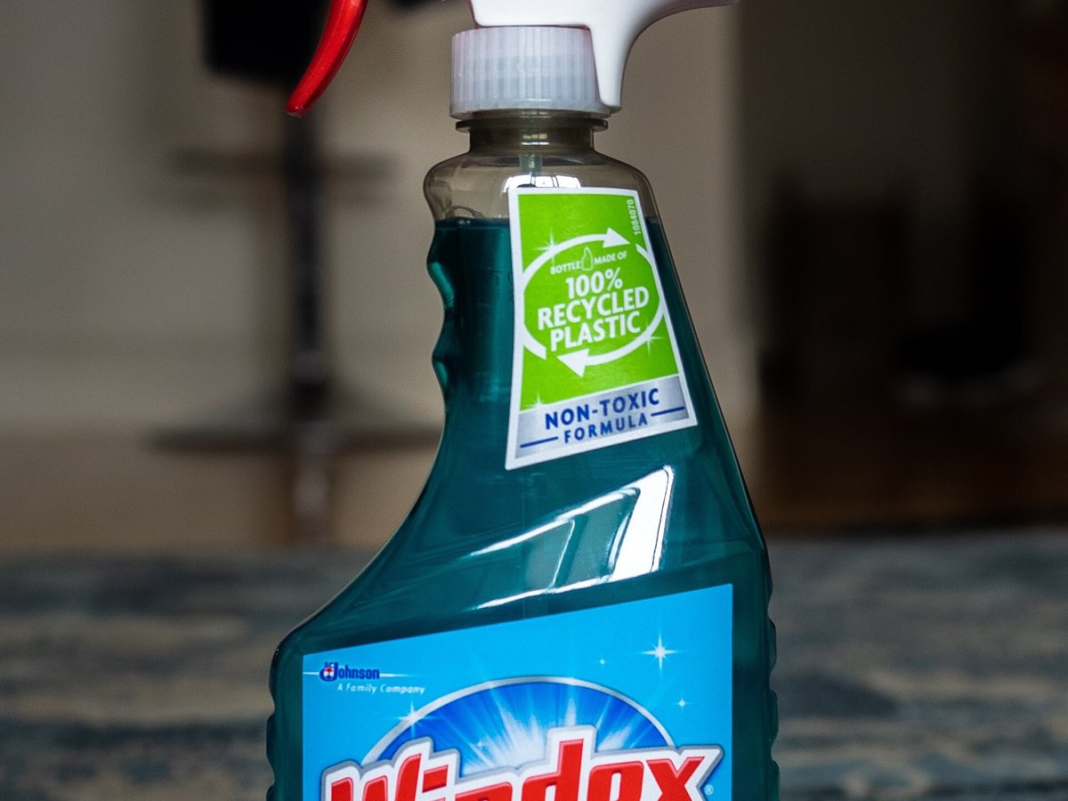 A bottle of Windex glass cleaner photographed close up in a living room
