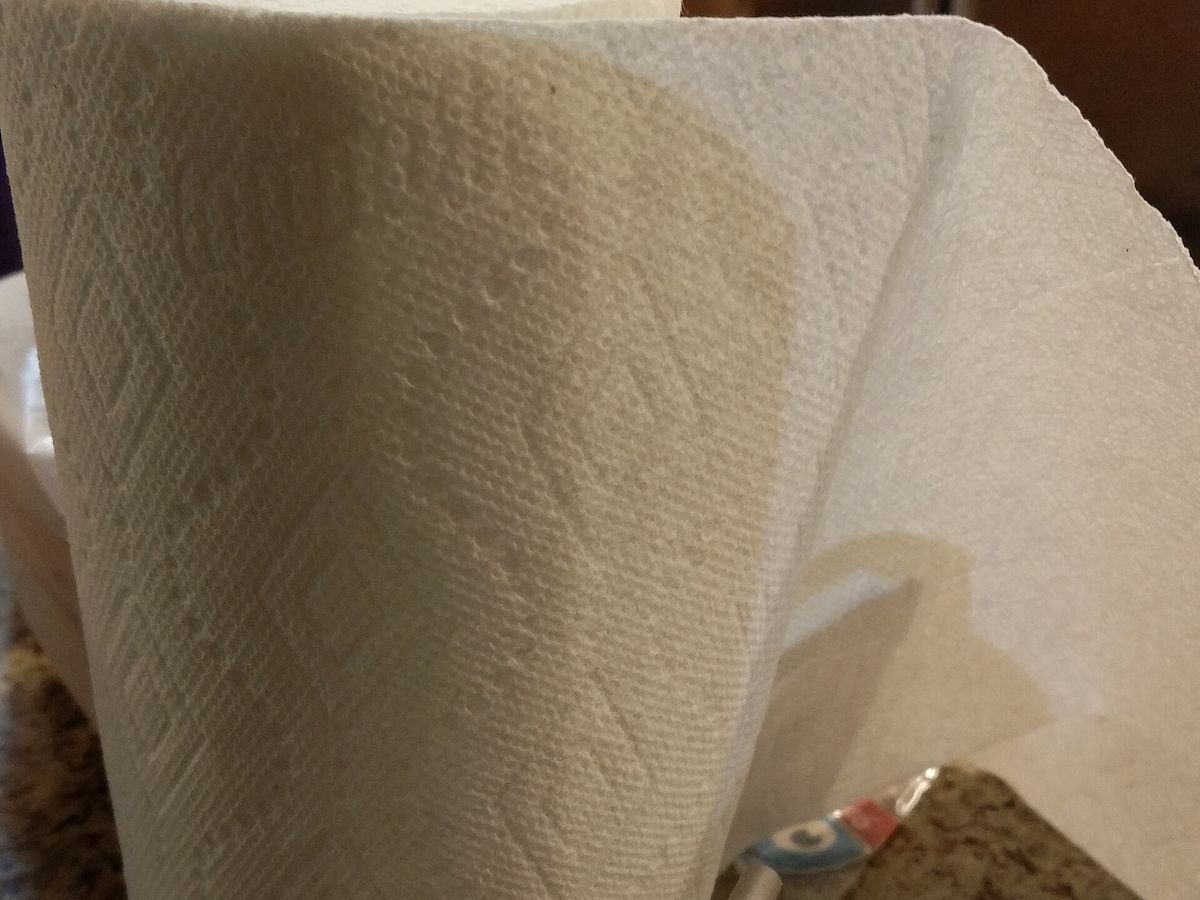 A roll of kitchen paper towel close up, showing the coarse embossed fibre texture