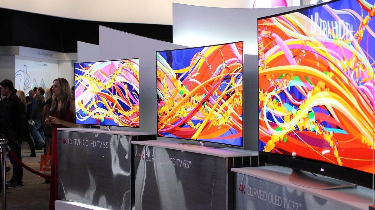 A row of curved OLED televisions on display at a trade show