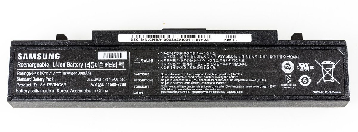 A removed black Samsung laptop lithium-ion battery pack resting on a dark surface
