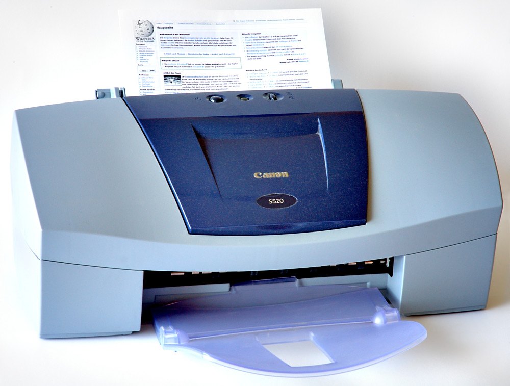 A Canon S520 inkjet printer with a sheet loaded in the rear tray, the kind of desktop printer you power-cycle to clear an offline error