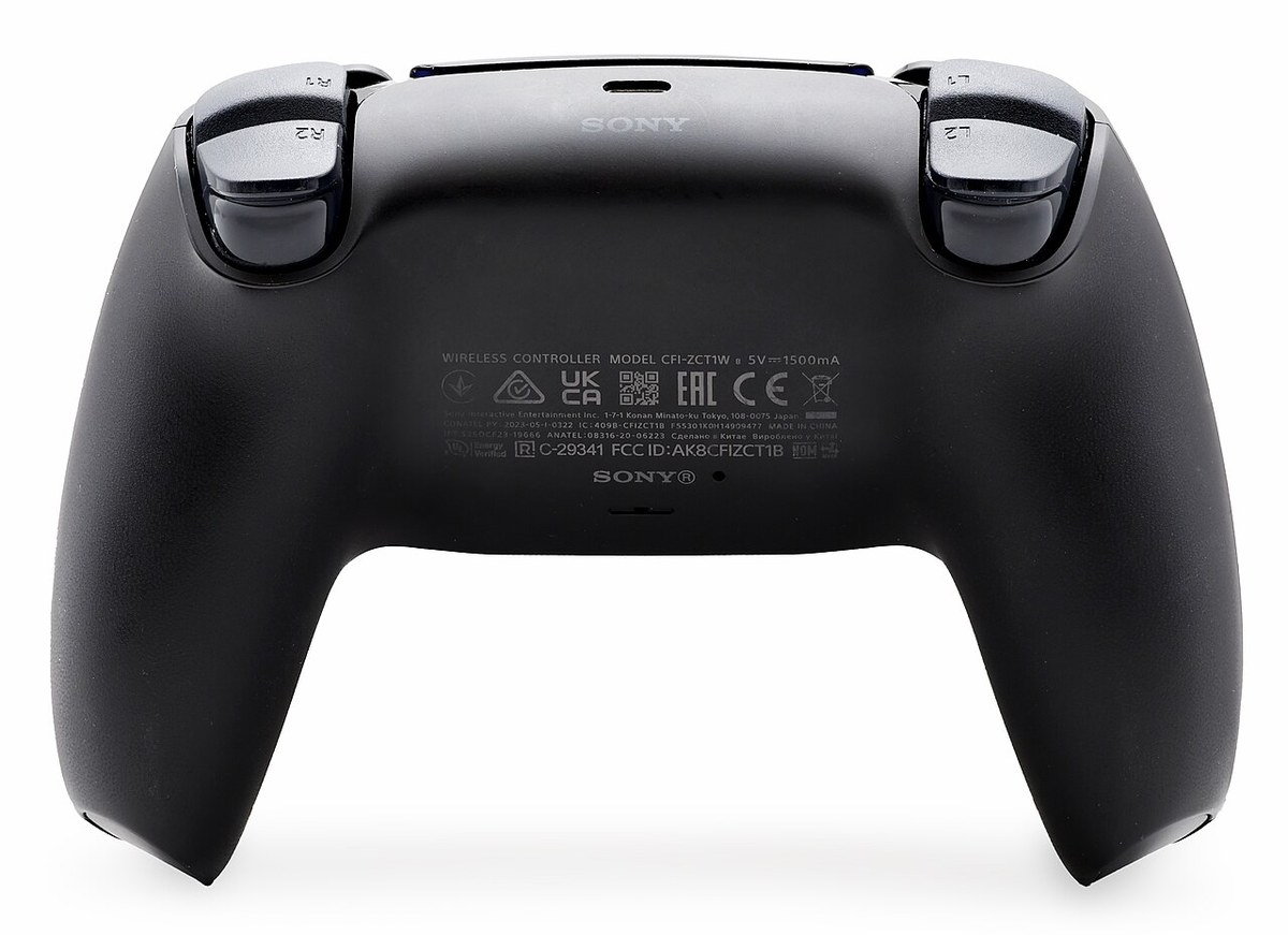 The back of a black DualSense controller showing the SONY label and the tiny recessed reset pinhole next to the SONY logo