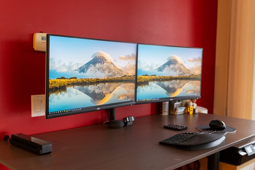 A dual-monitor desk setup with two matching Dell monitors side by side, the kind of second screen Windows sometimes fails to detect